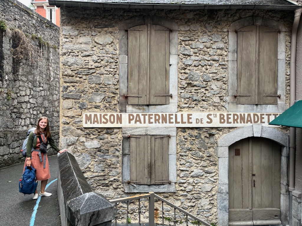 My older sister (Bernadette) in front of St. Bernadettes home in Lourdes, France  