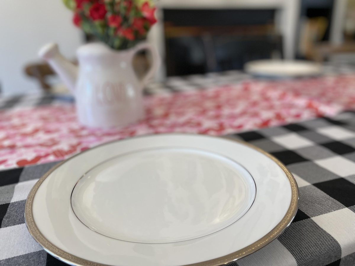 A plate and pitcher of flowers set on the table for the tea party. 